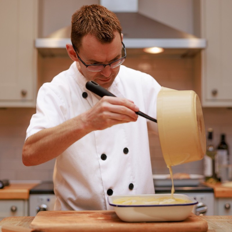 Shaun Nixon The Cook in the North pouring sauce by photographer Richard Willett